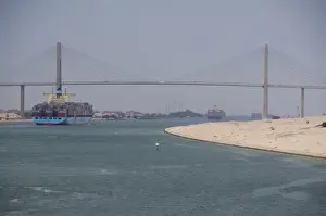 Transit Prints: Egypt, Suez Canal. Cargo ship passing under Bridge of Peace (aka Peace Bridge)