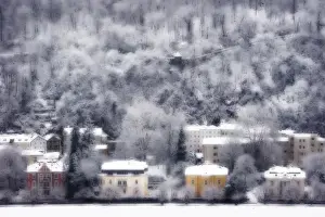 Austria Prints: Europe, Austria, Salzburg. Dreamlike view of residences and snow-covered trees on hillside