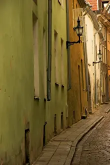 Baltic Prints: Europe, Estonia, Tallinn. Narrow cobblestone street with lamps on buildings. Credit as