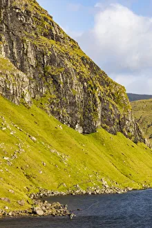 Europe, Faroe Islands. View of fly fishermen casting on the island of Streymoy