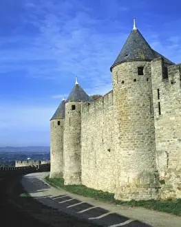 Europe, France, Carcassonne. Shadows of the crenelatted walls shade the pathway under