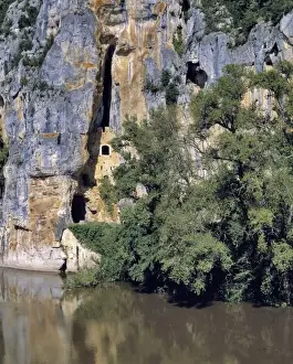 Lot River Prints: Europe, France, Lot River. Caves are carved into the limestone cliffs near St. Cirq