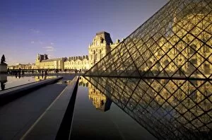 Europe, France, Paris. Le Louvre and glass pyramid with reflections in water
