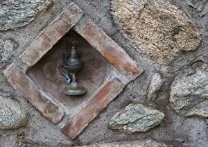 Europe, Greece, Meteora. Oil lamp embedded in stone wall at Grand Meteora Monastery
