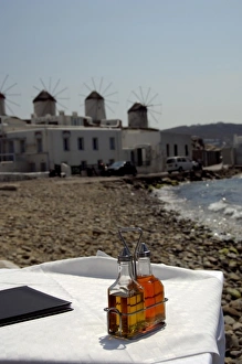 Cruise Port Prints: Europe, Greece, Mykonos. Waterfront cafe, historic windmills in distance