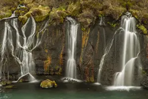 Europe, Iceland, Hraunfossar. Waterfalls flow over igneous rocks