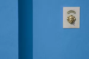 Europe, Italy, Burano. Blue wall and doorbell button within a brass lions head