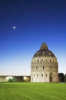 Europe, Italy, Pisa. The historic Baptistery, with an evening moon, in the Piazza Dei Miracoli