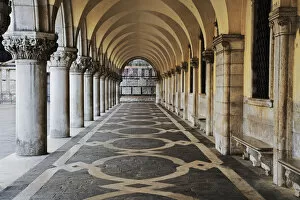 Europe, Italy, Venice. Columns and archways along a patterned passageway at the Doges Palace