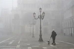 Images Dated 12th February 2009: Europe, Italy, Venice. A man walks his dog in San Marco Square near the Doge s
