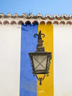 Iberian Prints: Europe, Portugal, Obidos. Wrought iron lantern hanging from a colorful stripped wall