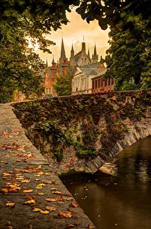 West Flanders Prints: Fall leaf strewn bridge over a canal in Bruges, Belgium