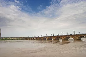 The famous old Pont de Pierre bridge across the Garonne river and the city at the