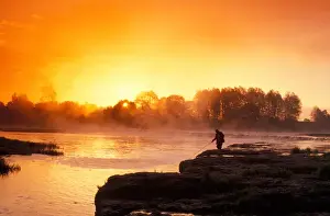 Fisherman Prints: Fisherman at sunrise on Venta River waterfall at city of Kuldiga in Kurzeme region