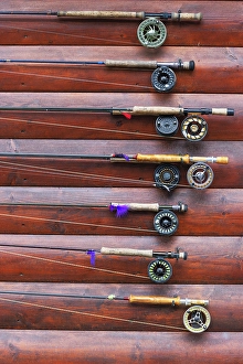 Cabin Prints: Several fishing rods hanging on cabin wall outside
