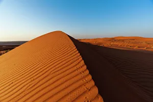 Footprint Prints: Footprints along the ridge of a sand dune at sunset. Wahiba Sands, Arabian Peninsula, Oman