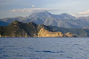 Coasts Prints: France, Corsica. Red rocks of L ale Rousse (Red Island) below mountainous interior