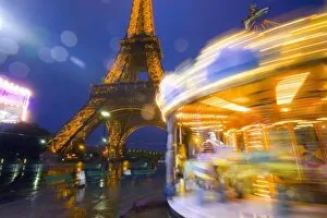 France, Paris. Eiffel Tower in twilight fog and rain at twilight with a merry-go-round