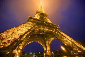 Base Prints: France, Paris. Looking up from base of Eiffel Tower lit at night. Credit as: Jim