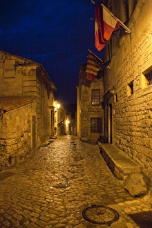 Images Dated 5th June 2009: France, Provence, Les Baux-de-Provence. Flags over deserted street inside castle at night
