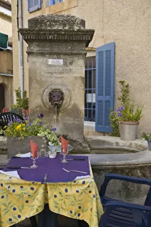 France, Provence, Lourmarin. Outdoor cafe tables wait for customers
