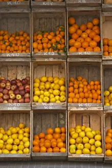 A fruit and vegetable shop displaying products in wooden crates on the street: tomatoes