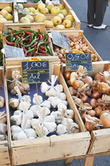 Garlic, onions and pimiento peppers for sale at a market stall at the street market in Bergerac