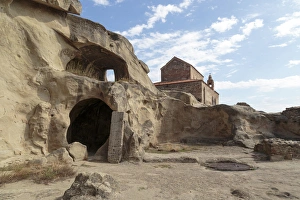 Georgia, Uplistsikhe. A room carved into a cliff face, with a church in the background
