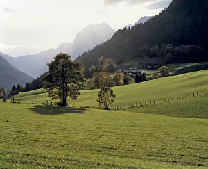 Germany, Bavaria, Ramsau. A cluster of farm houses nestle at the base of a hill near Ramsau