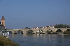 Riverfront Prints: Germany, Bavaria, Regensburg. Historic 12th century Old Stone Bridge over the Danube