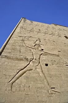 Giant figures and hieroglyphs on pylons of main entrance to Temple of Horus, at Edfu