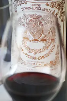 Chateau Longueville Prints: A glass of wine with the label of a bottle seen through the glass - label without vintage