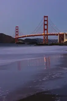 The Golden Gate Bridget at dusk reflected in the sands of Baker Beach, San Francisco