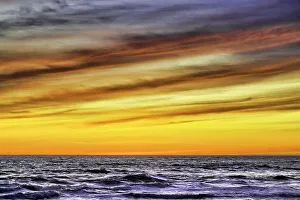Cloudscape Prints: The golden light of the setting sun reflects a gold glow on the beach at Pererenan Beach