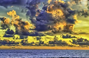 Cloudscape Prints: The golden light of the swirling clouds sunset reflects a pink glow on the beach at Pererenan Beach