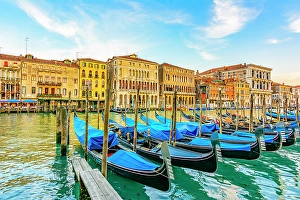 Grand Canal, Venice, Italy. Wide angle landscape view of medieval buildings and gondolas lining the canal at sunrise