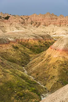 The grassy valley with dry creek is fed by the run off of the hoodoos lining the side