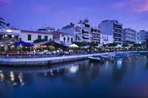 GREECE-CRETE-Lasithi Province-Agios Nikolaos: View of the Cafes by Voulismeni Lake / Dusk