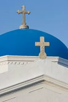 Greece, Mykonos. Blue Greek Orthodox church dome and crosses against blue sky