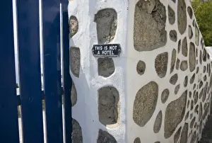 Notice Prints: Greece, Mykonos. Gate and stone wall with caution notice for tourists, This is not a hotel