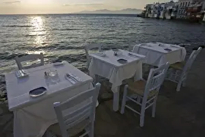 Hora Prints: Greece, Mykonos, Hora. Three dinner tables overlooking the sea at sunset. Credit as