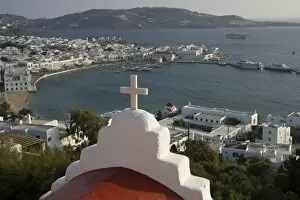 Greece, Mykonos, Hora. Greek Orthodox church and cross overlook harbor and town