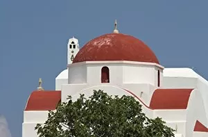 Greece, Mykonos, Hora. Red church dome and white walls against blue sky