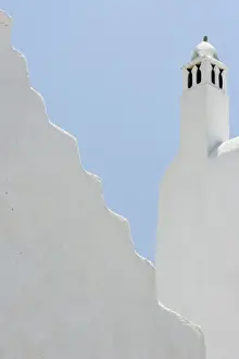 Hora Prints: Greece, Mykonos, Hora. Whitechurch belfry against light blue sky and irregular wall