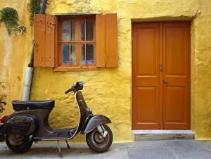 Images Dated 12th September 2018: Greece, Rhodes. Vespa motorbike and colorful house exterior
