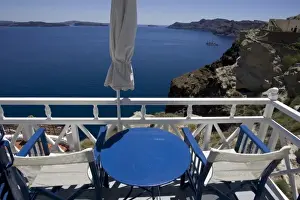 Folded Prints: Greece, Santorini. Blue and white patio chairs and table overlooking Aegean Sea