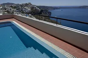 Patio Prints: Greece, Santorini. Swimming pool overlooking town of Firostefani and yachts on the Aegean Sea