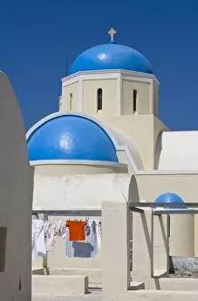 Images Dated 7th June 2005: Greece, Santorini, Thira, Oia. Blue Greek Orthodox church domes contrast with drying laundry
