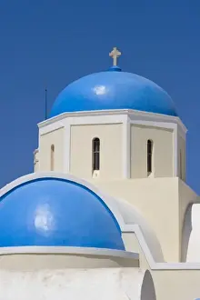 Greece, Santorini, Thira, Oia. Blue Greek Orthodox church domes against blue sky