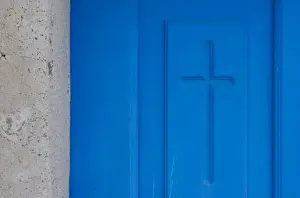 Thira Prints: Greece, Santorini, Thira, Oia. Christian cross symbol engraved in blue door